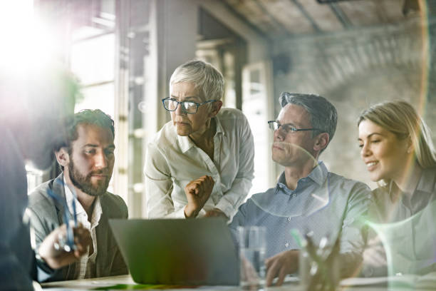 istock Business people talking while working on laptop during a meeting in the office. 1401329144