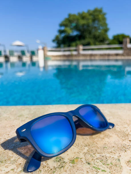 istock Blue mirror sunglasses on swimming pool background 1401329890