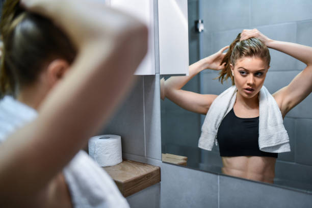 istock Cute Female Tying Hair After Workout And Getting Ready For Shower 1401330230