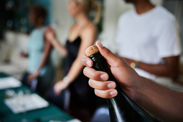 친구들과 저녁 파티에서 샴페인 한 병을 여는 젊은 남자 - cork wine bottle wine champagne 뉴스 사진 이미지