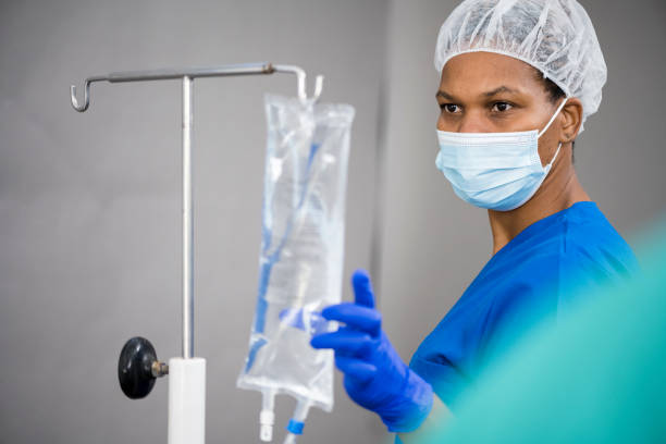 istock Nurse hanging IV drip on stand 1401331431
