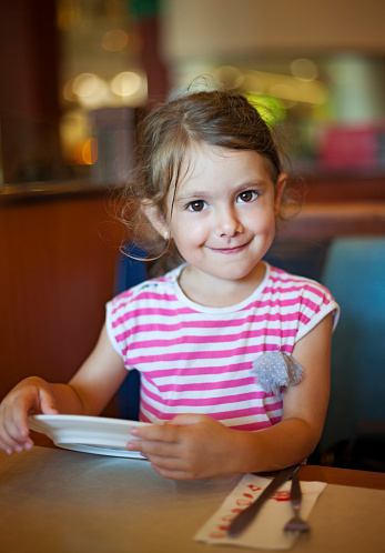Child waiting for her meal in the restaurant