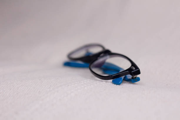 istock Eyeglasses with a black frame and blue temples close-up on a light background. 1401331960