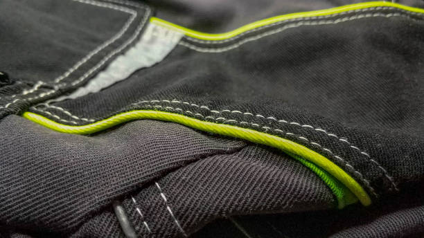 istock White stitching on black fabric. Texture of black working clothes with white stitching closeup, green reflective elements 1401332007