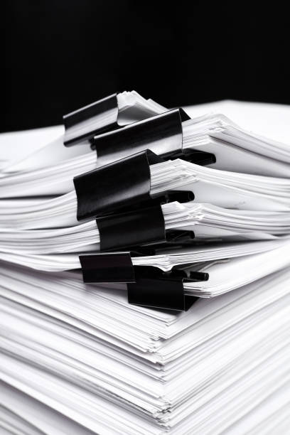 istock A stack of office papers, some of which are fastened with black binders 1401334582
