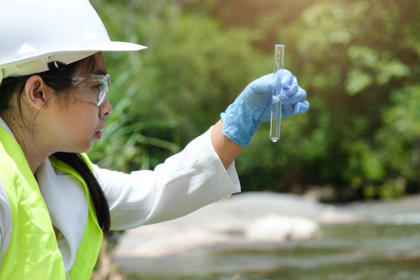 istock Female environmentalist hands in glove collects water samples from a river to explore and testing for infections. Water and ecology concept 1401337217