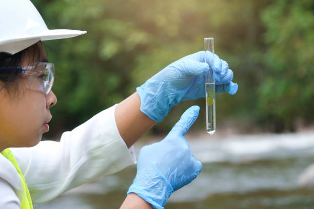 istock Female environmentalist hands in glove collects water samples from a river to explore and testing for infections. Water and ecology concept 1401337218