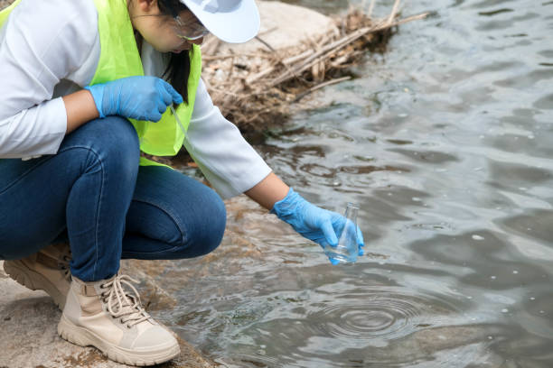 istock Female environmentalist hands in glove collects water samples from a river to explore and testing for infections. Water and ecology concept 1401337223