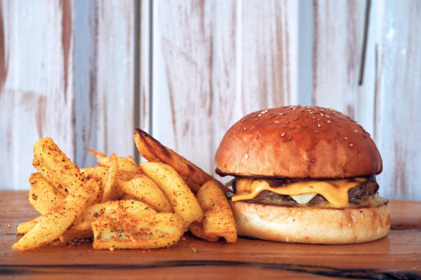 un hamburger, hamburger o cheeseburger su piatto di legno con patatine fritte patatine fritte. - sandwich turkey potato chip plate foto e immagini stock