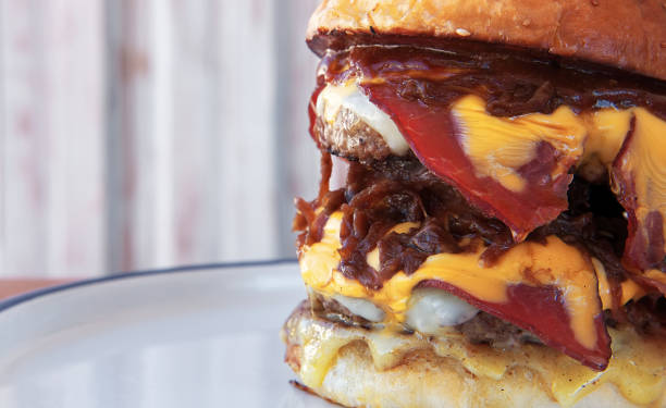 istock One big tall hamburger, burger, or cheeseburger with smoked meet on a plate. 1401339952