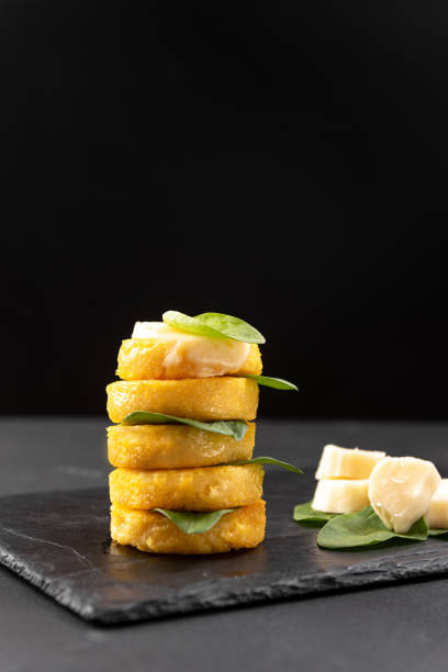 Fried polenta on a blackened background with macarella cheese. Side view with blank space for text