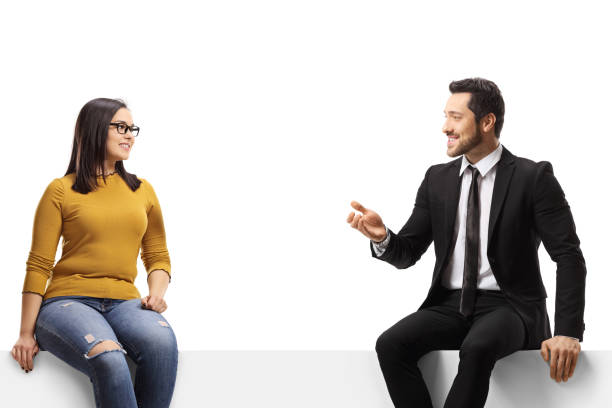 istock Businessman talking to a young casual female and sitting on a panel 1401340974