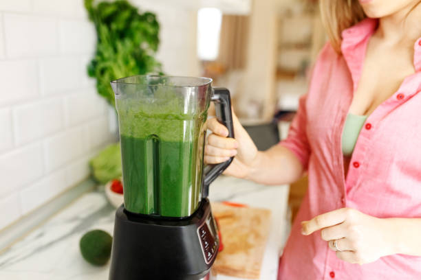 istock Woman preparing tasty green smoothie in kitchen 1401341279