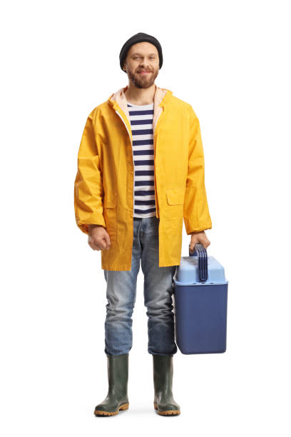 istock Fisherman in a raincoat and boots holding a portable fridge 1401342591