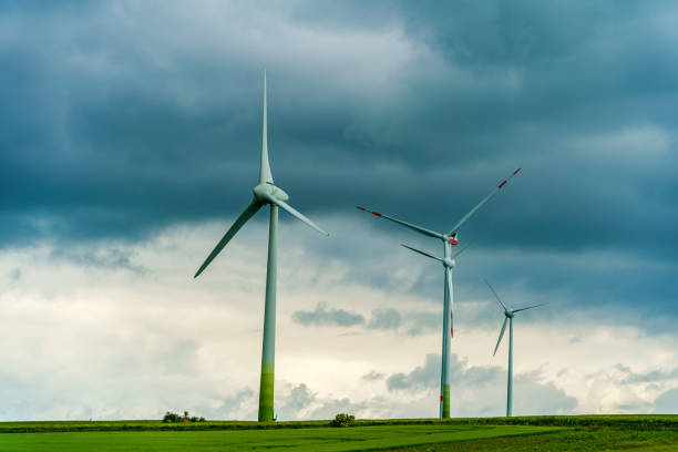 Looking at wind turbines in front a upcoming storm with rainy clouds.