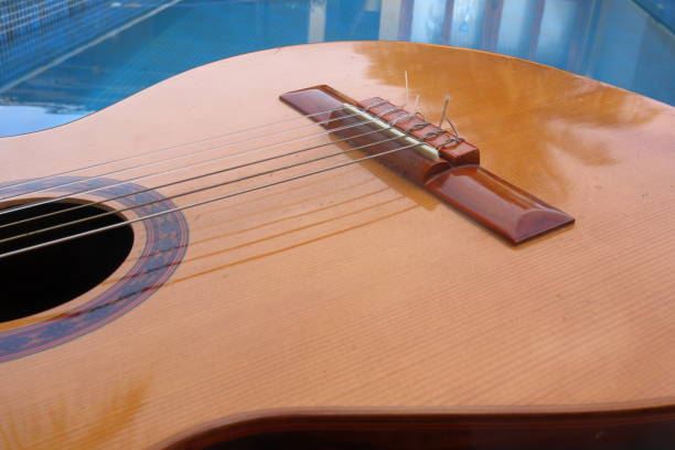 istock Acoustic guitar with a pool in the background under the sunlight 1401344849