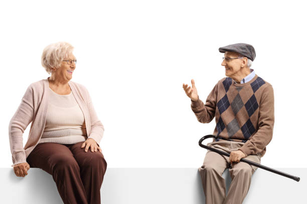 istock Elderly man and woman sitting on a blank panel and having a conversation 1401345107