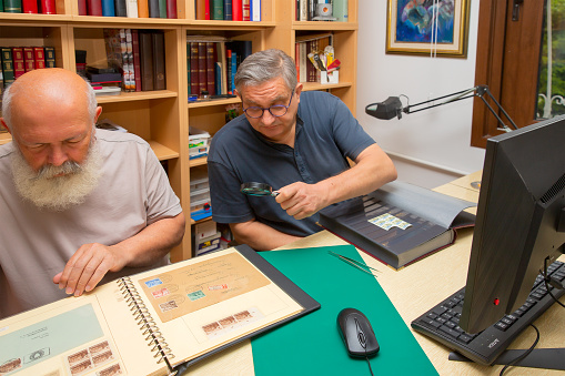 Senior men organizing stamp collection