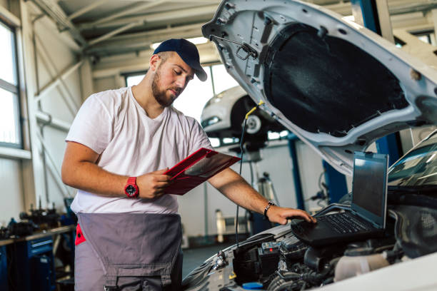 istock Man writing on a clipboard in a garage. 1401347034