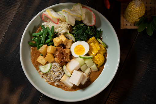 Gado-Gado or Indonesian Salad with Peanut Sauce is an Indonesian salad of raw, slightly boiled, blanched or steamed vegetables and hard-boiled eggs, boiled potato, fried tofu and tempeh, and lontong (rice wrapped in a banana leaf), served with a peanut sauce dressing.