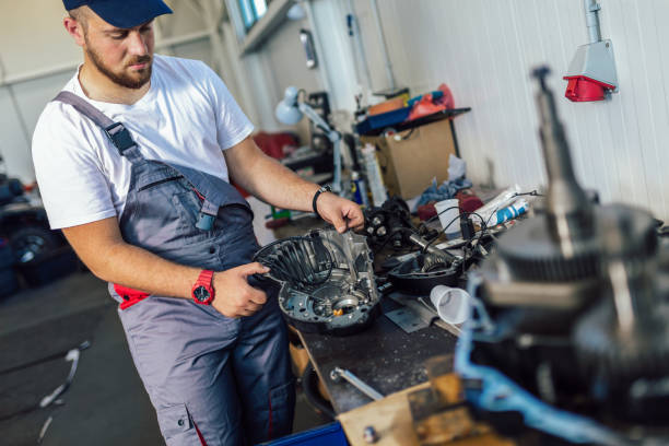 istock Technician working on checking and service car in workshop garage; technician repair and maintenance engine of automobile in car service 1401347176