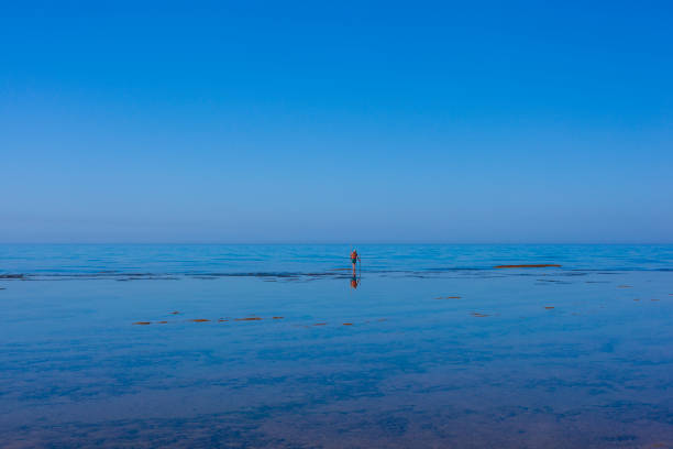 Scenic view of Sicily sea where an elderly man fishing with sticks