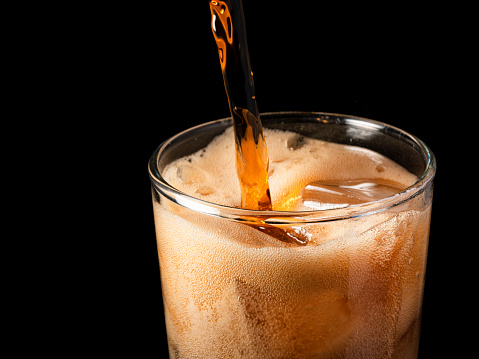 Close-up iced cola isolated in the black background