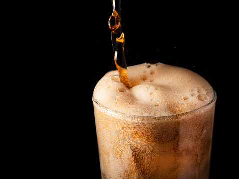 Close-up iced cola isolated in the black background