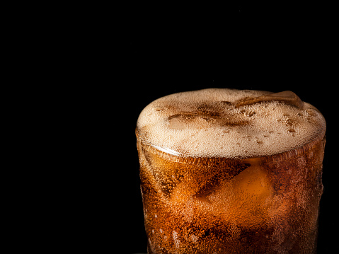 Close-up iced cola isolated in the black background