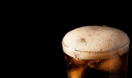 Close-up iced cola isolated in the black background