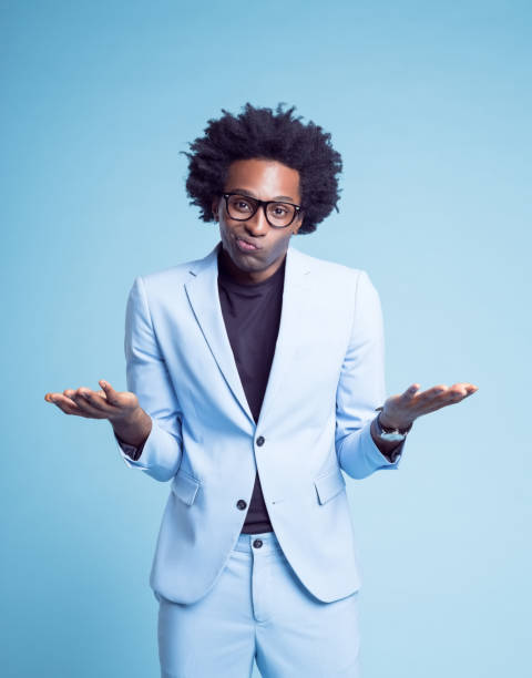 istock Confused businessman gesturing against blue background 1401348470