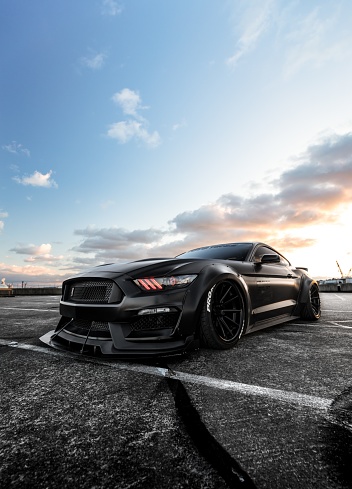 Seattle, WA, USA
7/12/2022
Mustang Shelby GT in black parked in a parking lot with a clear sky above with a few clouds