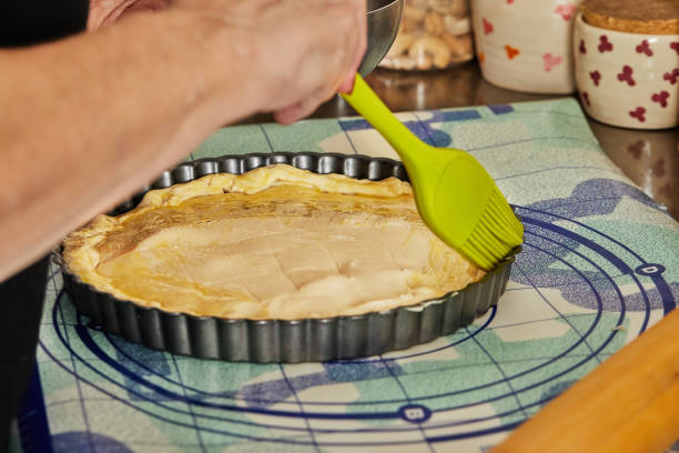 Chef uses special brush to brush the pie dough with egg before baking in the oven.