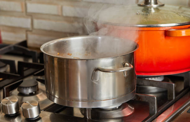 istock Pots with steam boiling on gas stove in the kitchen 1401352444