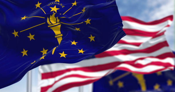 The Indiana state flag waving along with the national flag of the United States of America. stock photo