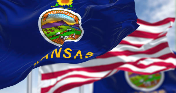 The Kansas state flag waving along with the national flag of the United States of America stock photo