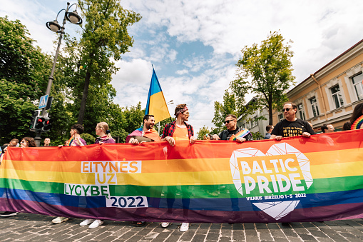 Vilnius, Lithuania, Europe - June, 4, 2022: Baltic LGBTQ+ pride at Vilnius,  rainbow flag and balloon at the European street. Happy pedestrian walking for Human Rights.