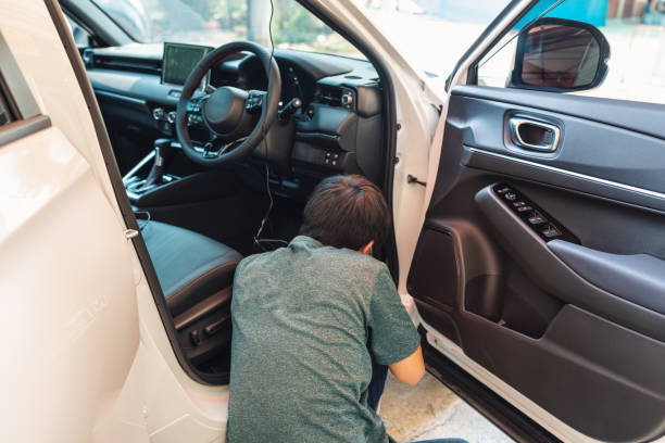 istock Mechanic man checking and installing dash cam device with wire inside a car at garage 1401358384