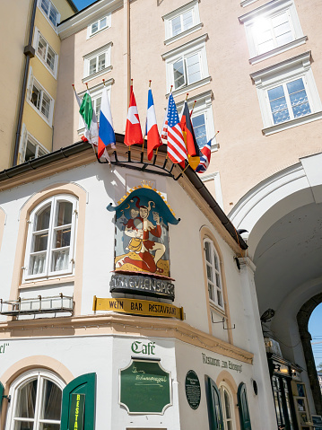 Mozart plaque on side of restaurant in Salzburg, Austria.  The entrance with a jester sign.