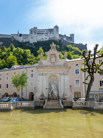 The view over Salzburg, Austria on a bright spring evening.  In the foreground Chapter Fountain  The new fountain was built under Archbishop Leopold Firmian in 1732 to plans by Franz Anton Danreiter. In the background is the Hohensalzburg fortress.