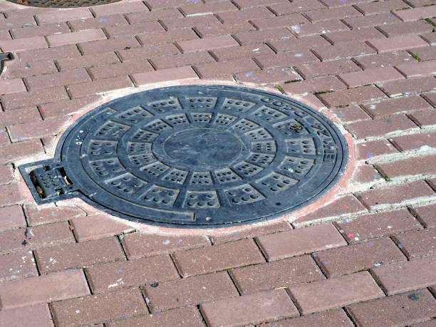 istock Sewer manholes on the cobblestone pavement 1401361309