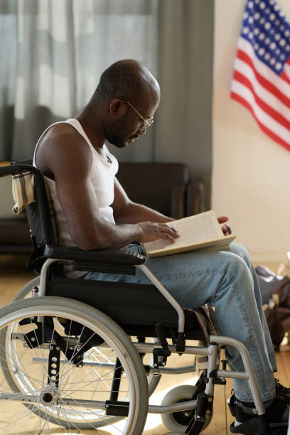 istock Disabled man reading a book at home 1401361361