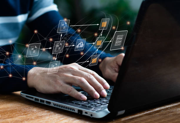 istock Archiving, finding, and managing business files and information software. IT expert works on laptop computer in workplace setting up Document Management System (DMS). 1401361513