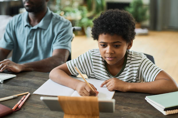 istock Little boy studying online at home 1401362545
