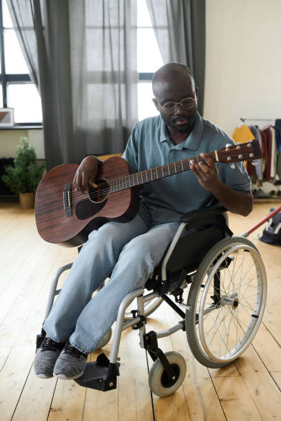 istock Disabled man playing guitar at home 1401362698