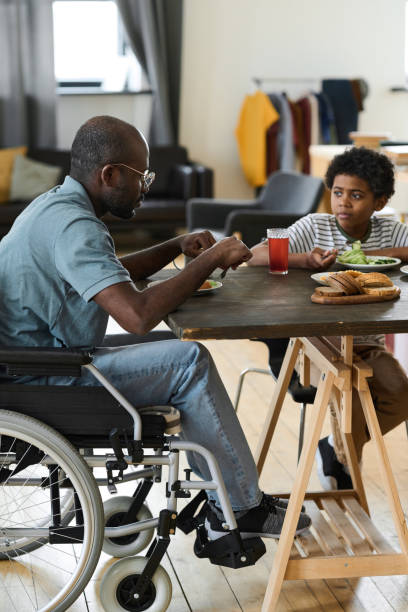 disabled father and son having lunch together - physical impairment wheelchair disabled accessibility imagens e fotografias de stock