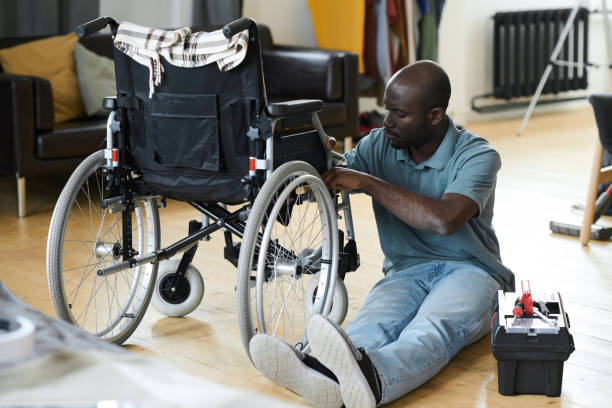 disabled man fixing his wheelchair - physical impairment wheelchair disabled accessibility imagens e fotografias de stock