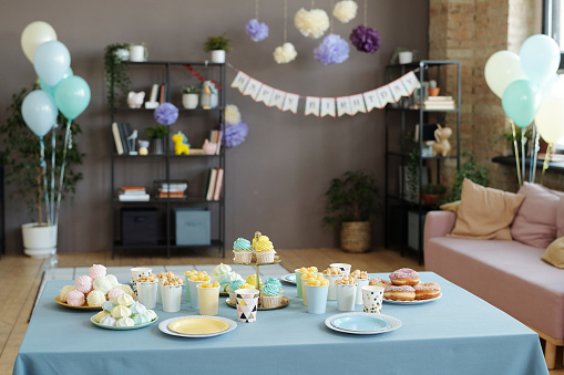 Image of holiday table served with desserts, cupcakes, donuts and other sweets preparing for birthday party at home