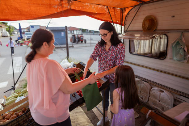 istock Mother and daughter selling vegetables 1401364626