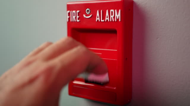 Slow Motion View Activating Fire Alarm in Building